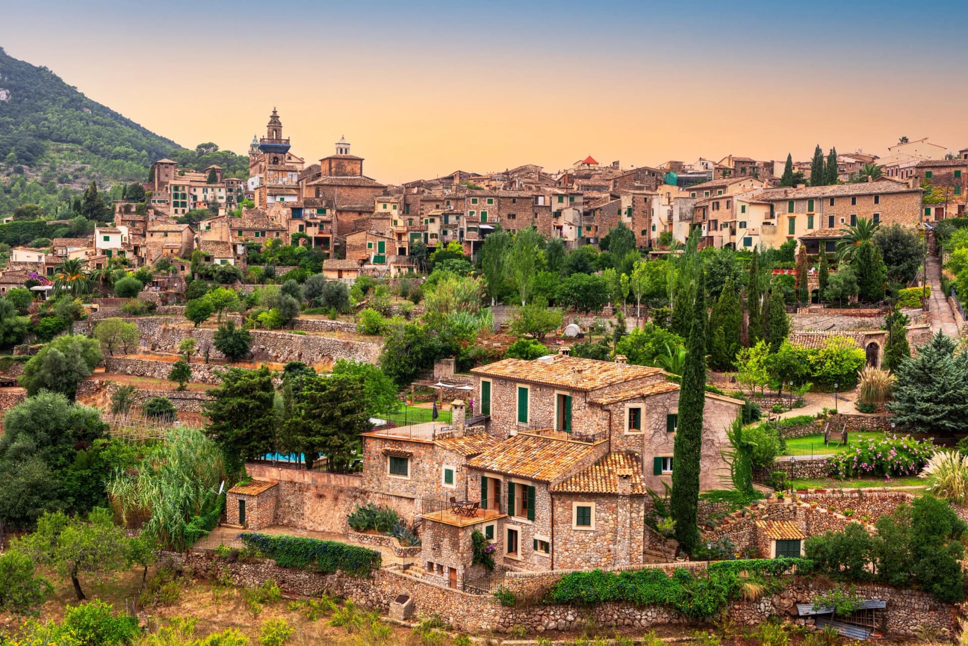 Hillside village with stone houses, green shutters, and terraced gardens in Valldemossa.