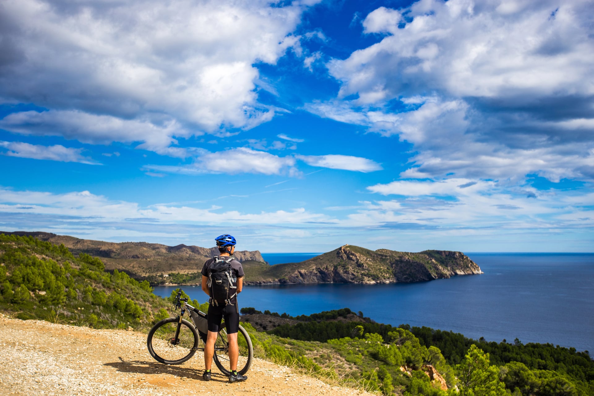 https://spain-cycling-holidays.com/_next/image?q=85&url=https%3A%2F%2Fcdn.world-discovery.com%2F43995%2Fa-young-guy-on-a-mountain-bike-trails-in-spain-and-takes-a-photo-on-a-white-phone-in-the-background-of-the-mediterranean-sea-of-the-rocky-coast-of-the-costa-brava-k.webp&w=1920