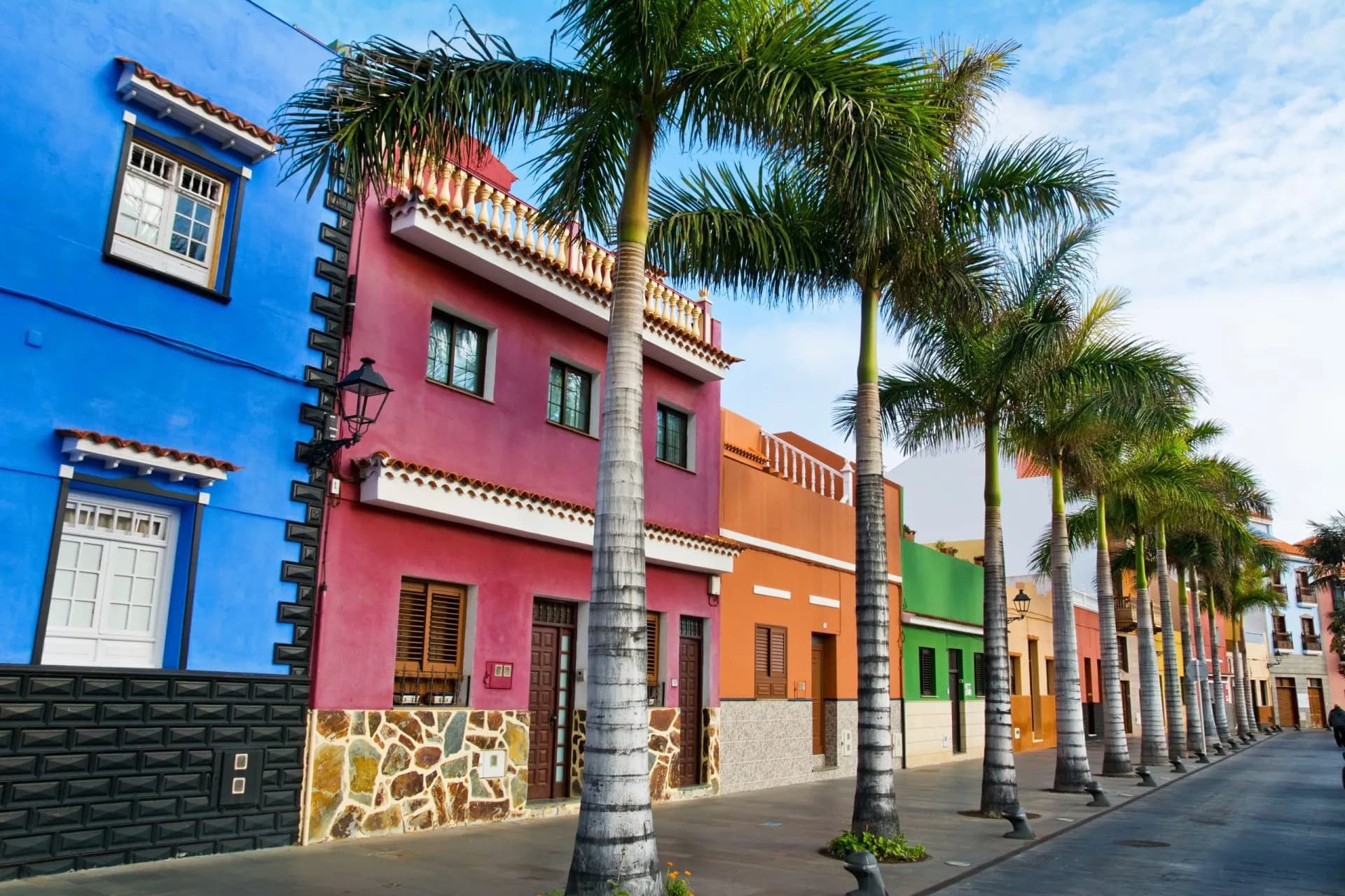 Colourful houses and palm trees line a street in Puerto de la Cruz, Tenerife, Canary Islands.