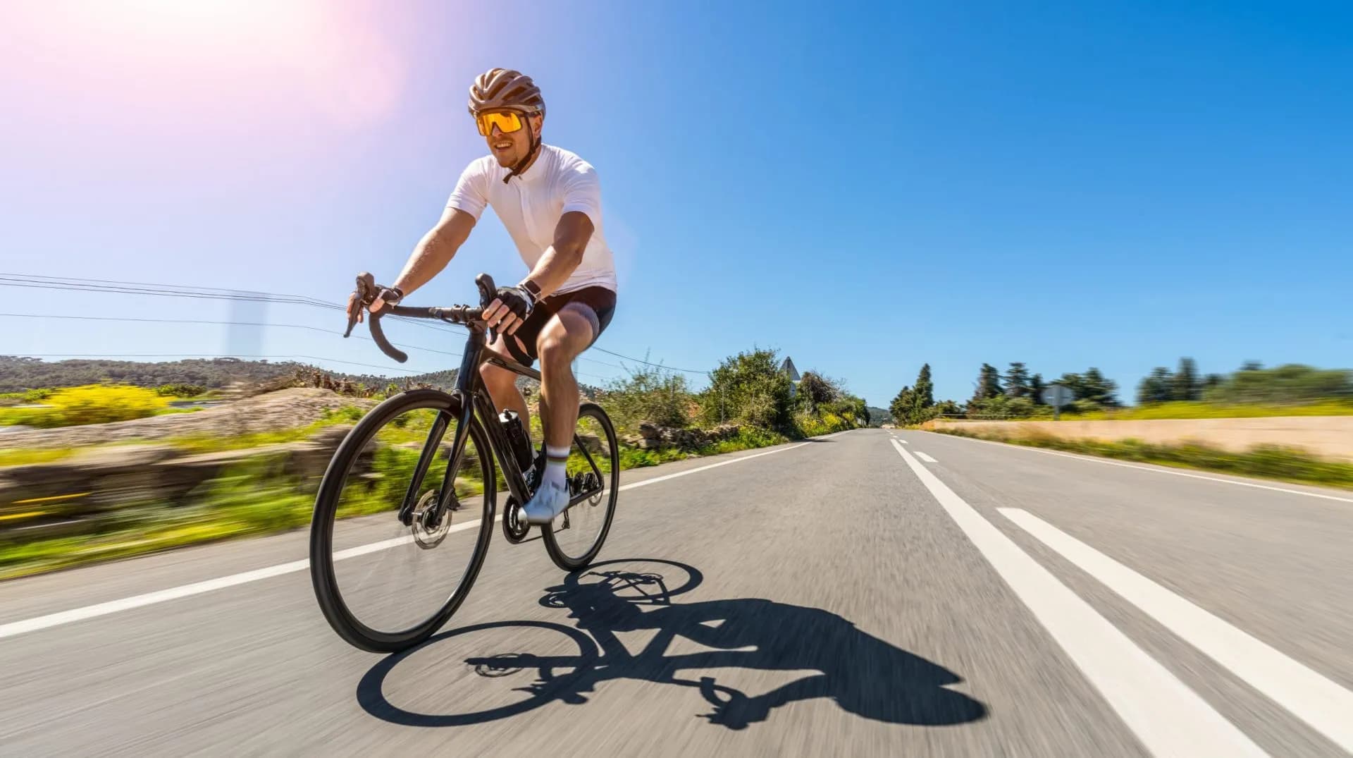 Man Adult on a racing bike climbing the hill at mediterranean sea landscape coastal road on mallorca balearic island. motion blur shot