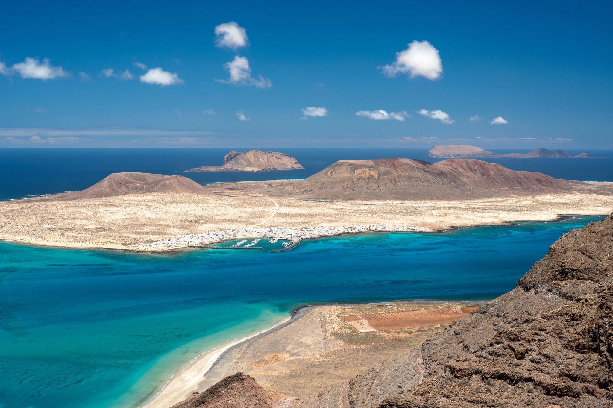 Aerial shot of cliffs in north of Lanzarote with view of La Graciosa, Canary Islands