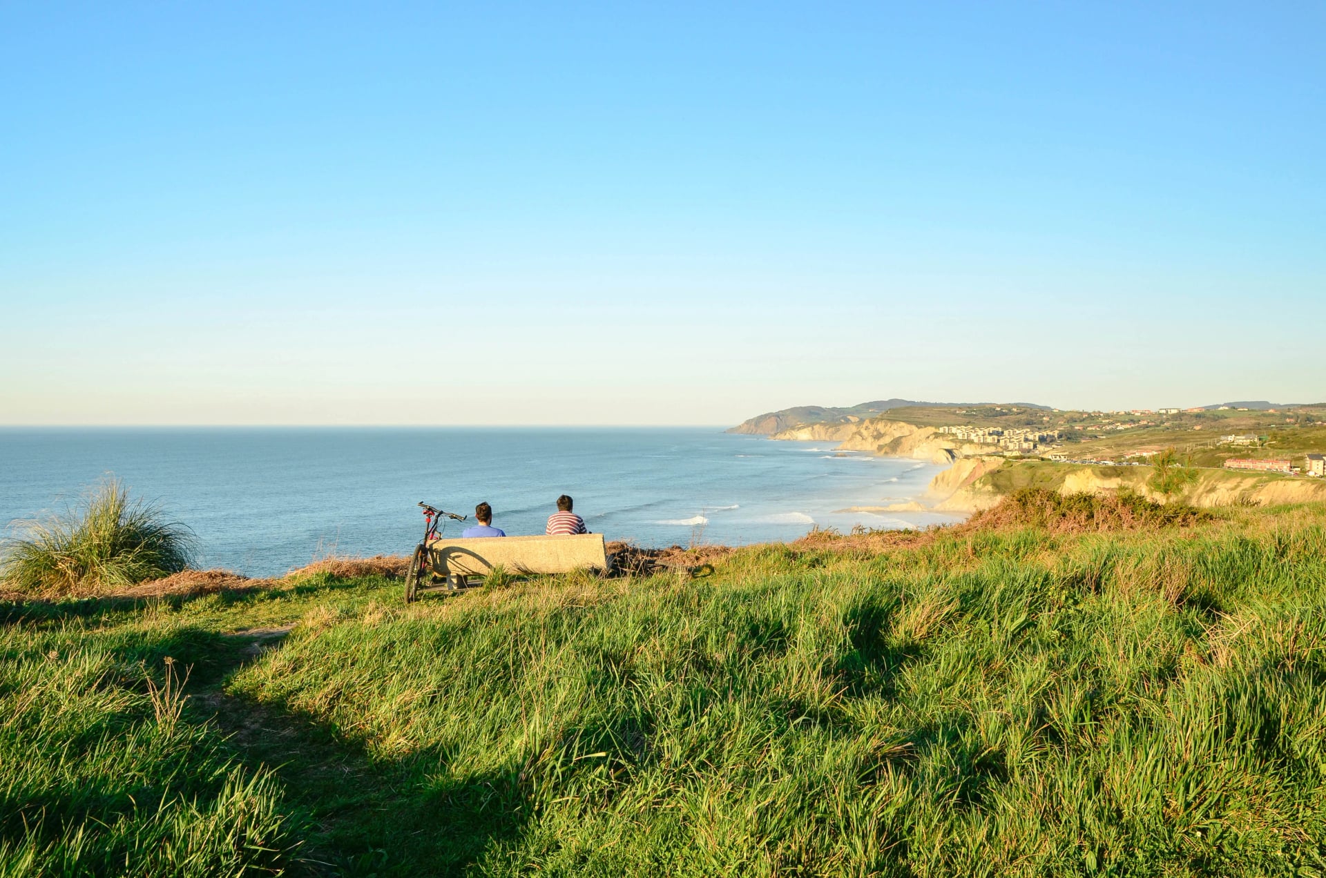Two friends sitting looking at the views of Sopelana,Vizcaya,Basque Country