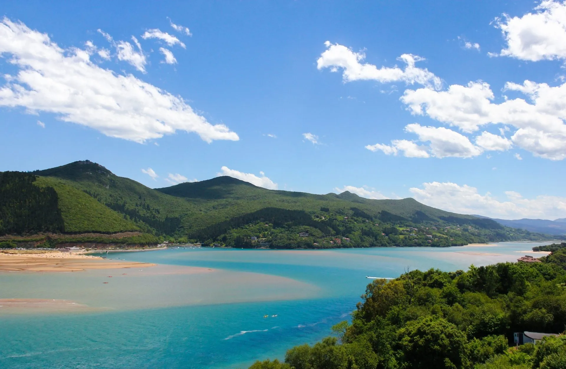 Splendida vista della riserva della biosfera di Urdaibai con montagne, cielo azzurro e nuvole bianche sullo sfondo, nei Paesi Baschi